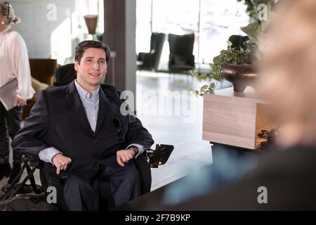 In der Hotellobby befindet sich ein Rollstuhlfahrer Stockfoto