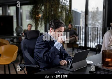 Geschäftsmann im Café mit Blick auf digitale Tablets Stockfoto