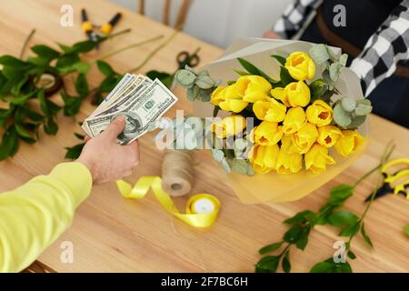 Frau Floristin verkauft Blumen an einen Mann Stockfoto