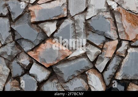 Raue Steinwand-Struktur. Marmor. Steinmauer in der Straße. Hintergrund Stockfoto