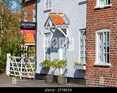 Haus mit verkauftem Schild im Dorf Lockington, East Yorkshire, England Stockfoto