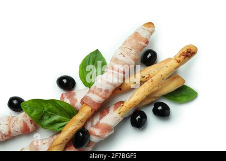 Grissini Sticks mit Speck, Oliven und Basilikum isoliert auf weißem Hintergrund Stockfoto