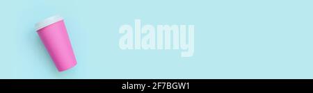 Einfach flach Lay Design rosa Papier Kaffeetasse auf blauem pastellfarbenem Hintergrund. Behälter für Getränke zum Mitnehmen. „Guten Morgen, wach auf“-Konzept Stockfoto
