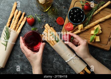 Leckeres Essen mit Wein, Grissini-Stäbchen und Snacks, Ansicht von oben. Ansicht von oben von Wein mit Grissini-Brotstäbchen und Snacks, Aperitif-Konzept Stockfoto