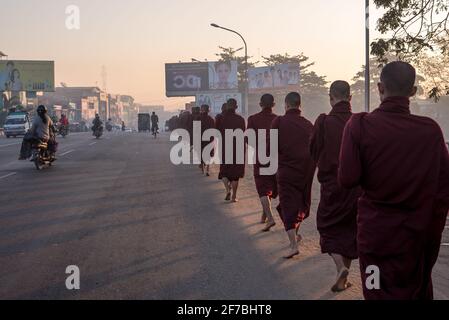 Mönche, die in den Straßen von Bago spazieren und Lebensmittelspenden sammeln, Bago, Myanmar Stockfoto