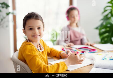 Zwei Schulmädchen Schwestern zuhause, Fernunterricht. Stockfoto