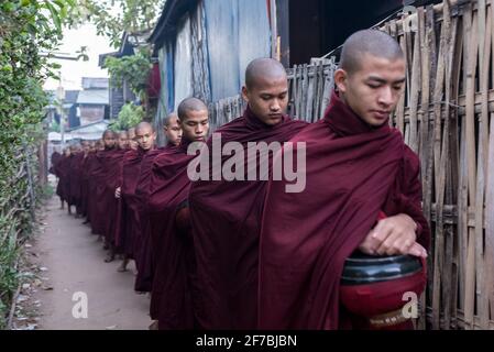 Mönche, die in den Straßen von Bago spazieren und Lebensmittelspenden sammeln, Bago, Myanmar Stockfoto