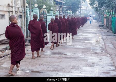 Mönche, die in den Straßen von Bago spazieren und Lebensmittelspenden sammeln, Bago, Myanmar Stockfoto