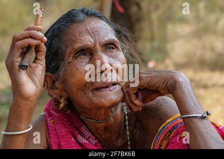 Chatikona, Indien - 2021. Februar: Eine Adivasi-Frau vom Stamm Desia Kondh raucht am 17. Februar 2021 auf dem Chatikona-Markt in Odisha, Indien. Stockfoto