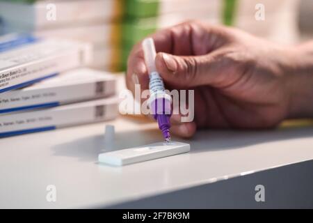 Berlin, Deutschland. April 2021. Eine Frau tropft nach dem Abtupfen für einen Corona-Schnelltest eine Lösung auf die Antigentestkassette. Quelle: Kira Hofmann/dpa-Zentralbild/ZB/dpa/Alamy Live News Stockfoto