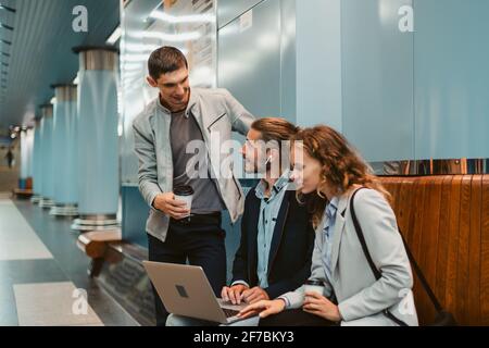 Junge Geschäftsleute mit einem Laptop auf dem U-Bahnsteig. Stockfoto