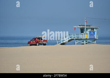 Landschaft mit einem blauen Lifeguard-Wachturm und einem roten Lifeguard-Pick-up-Truck am Sandstrand von Venedig in Los Angeles, Kalifornien, USA. Stockfoto