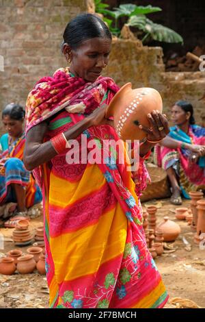 Kunduli, Indien - 2021. Februar: Adivasi-Frau vom Stamm Kondh kauft am 19. Februar 2021 auf dem Kunduli-Markt in Odisha, Indien, Tonvasen ein Stockfoto