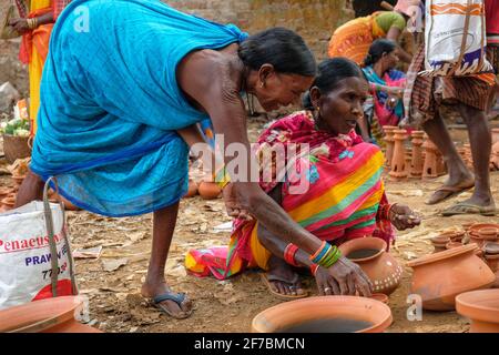 Kunduli, Indien - 2021. Februar: Adivasi-Frauen vom Stamm Kondh kaufen am 19. Februar 2021 auf dem Kunduli-Markt in Odisha, Indien, Tonvasen ein Stockfoto