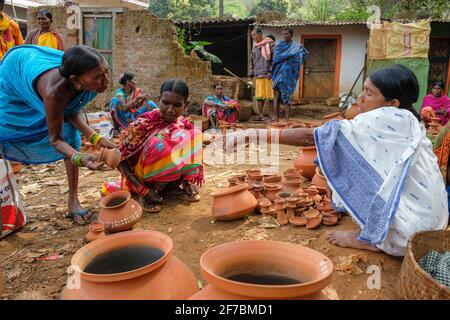 Kunduli, Indien - 2021. Februar: Adivasi-Frauen vom Stamm Kondh kaufen am 19. Februar 2021 auf dem Kunduli-Markt in Odisha, Indien, Tonvasen ein Stockfoto