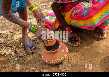 Kunduli, Indien - 2021. Februar: Adivasi-Frauen vom Stamm Kondh kaufen am 19. Februar 2021 auf dem Kunduli-Markt in Odisha, Indien, Tonvasen ein Stockfoto