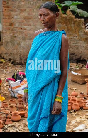 Kunduli, Indien - 2021. Februar: Adivasi-Frau vom Stamm Kondh kauft am 19. Februar 2021 auf dem Kunduli-Markt in Odisha, Indien, Tonvasen ein Stockfoto