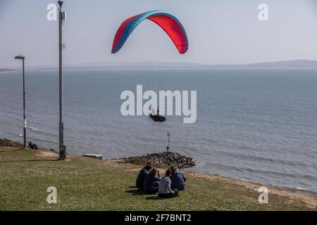 Paragleiter fliegen an einem windigen Tag entlang der Südwestküste der englischen Riviera, Dorset, England, Großbritannien, über den Strand von Highcliffe. Stockfoto