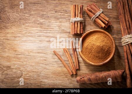 Zimtstangen und Pulver auf einem Holztisch, Draufsicht Stockfoto