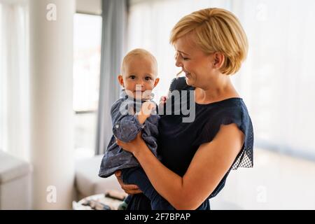 Frohe Familie. Mutter und Tochter spielen, umarmen, zu Hause küssen Stockfoto