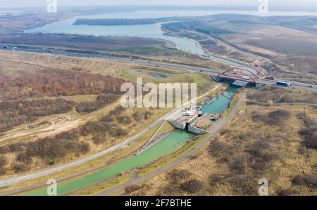 26. März 2021, Sachsen, Markkleeberg: Die Schleuse zwischen Markkleeberger See (l) und Störmthaler See ist von Hangrutschungen betroffen. Risse im Kanaldamm zwischen den Gewässern erfordern sofortige Sicherungsmaßnahmen. Der 850 Meter lange Störmthal-Kanal verbindet die beiden Seen - die betroffene Schleuse gleicht die vier Meter unterschiedliche Wasserspiegelung der beiden Gewässer aus. Experten zufolge würde ein vollständiger Einsturz zu großflächigen Überschwemmungen führen - in den nördlichen Stadtgebieten von Markkleeberg bis Leipzig. Jetzt Tauchen, Surfen, Segeln und Schwimmen sowie alle Bootfahren auf den Seen Stockfoto