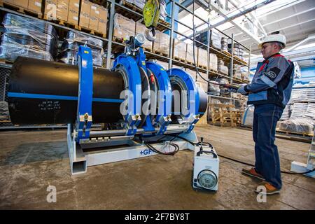 Stepnogorsk, Kasachstan - 04. April 2012: Produktionsanlage für Kunststoffrohre. Ingenieur für die Einstellung von Rohrleitungen, die die Verbindungsausrüstung verbinden. Stockfoto