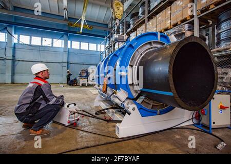 Stepnogorsk, Kasachstan - 04. April 2012: Produktionsanlage für Kunststoffrohre. Ingenieur für die Einstellung von Rohrleitungen, die die Verbindungsausrüstung verbinden. Stockfoto