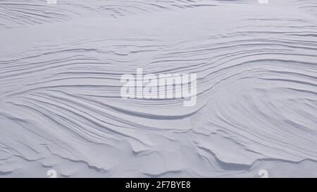 Natürliche wellige Linien auf der Oberfläche von reinem weißen Schnee Stockfoto