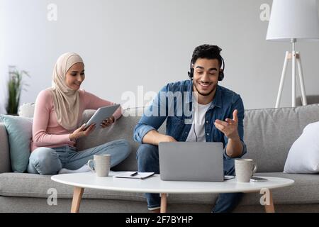 Positive muslimische Familie, die während einer Pandemie online arbeitet Stockfoto