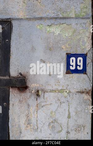 Nummer 99, Hausnummer, Hausnummer, Metalltür links Stockfoto