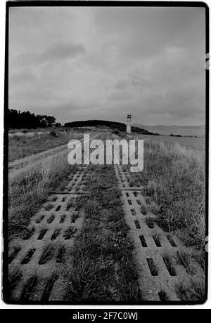 Deutschland 1994 Fulda Gap Point Alpha 1994 Panzergleise auf der ehemaligen Ostseite der Grenze und ostdeutscher Aussichtsturm mit Blick nach Westen. Die Fulda-Lücke, ein Gebiet zwischen der Hessen-Thüringer Grenze (ehemalige innerdeutsche Grenze) und Frankfurt am Main, Es enthält zwei Tieflandkorridore, durch die Panzer bei einem überraschenden Angriff der Sowjets und ihrer Verbündeten des Warschauer Paktes gefahren sein könnten, um die Überquerung des Rheins zu erreichen.[1] die nach Fulda benannte Fuldaer Lücke wurde während des Kalten Krieges von 1947-1991 als strategisch wichtig angesehen Stockfoto