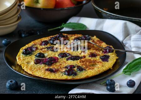 Gesundes Pfannkuchengericht mit einem Haferflocken-Pfannkuchen mit Heidelbeeren Und serviert auf einem Teller auf Küchentisch Hintergrund Stockfoto