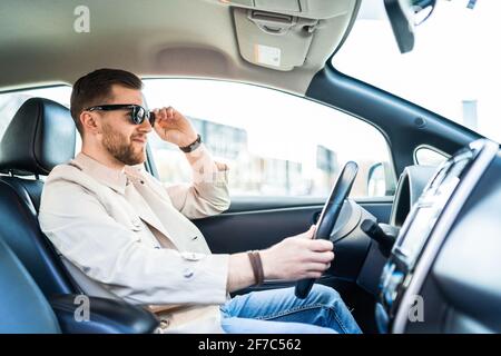 Stilvoller Mann in Sonnenbrille, der Auto fährt Stockfoto