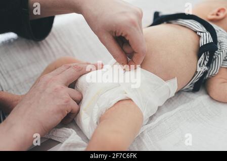 Hochwinkelige Ansicht der Eltern, die die Windeln eines Neugeborenen wechseln Baby Stockfoto