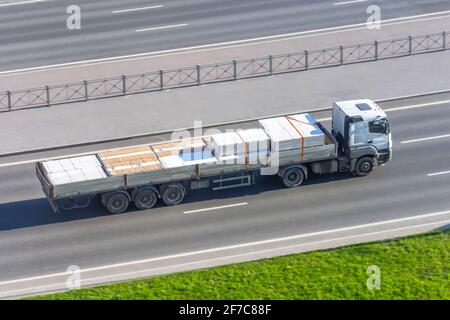 Transport und Lieferung von Fracht in einem offenen LKW auf der Autobahn, verpackt und gesichert Ladung Stockfoto