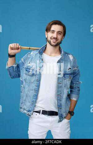 Lächelnder männlicher Schlagzeuger, der Schlagzeuger hält Stockfoto