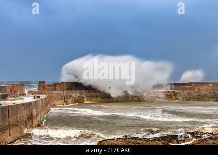 PORTKNOCKIE MORAY COAST SCOTLAND SCHWERER STURM UND SEHR STARKE WINDE WELLEN- UND SPRÜHSTOSS AN DER HAFENMAUER Stockfoto