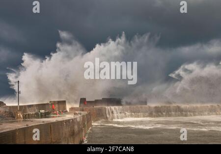 PORTKNOCKIE MORAY COAST SCOTLAND SCHWERER STURM UND SEHR STARKE WINDE WELLEN UND SPRÜHNEBEL KRACHEN UND BRECHEN ÜBER DIE HAFENMAUERN Stockfoto