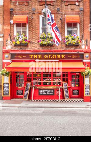 Traditioneller britischer Pub The Globe mit Union Jack und hängenden Blumen in London Stockfoto
