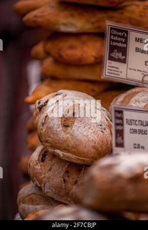 Rustikale Brotlaibe aus Kunsthandwerk werden am Oliver's Bakery Market Stand in London ausgestellt Stockfoto