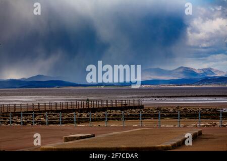 Heysham, Lancashire, Großbritannien. April 2021. Winterliche Duschen über den South Lakeland Fells von Heysham aus über die Morecambe Bay Quelle: PN News/Alamy Live News Stockfoto