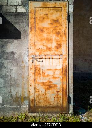 Detail einer rostigen Tür einer Fabrik. Frontalansicht. Niemand drinnen. Speicherplatz kopieren Stockfoto