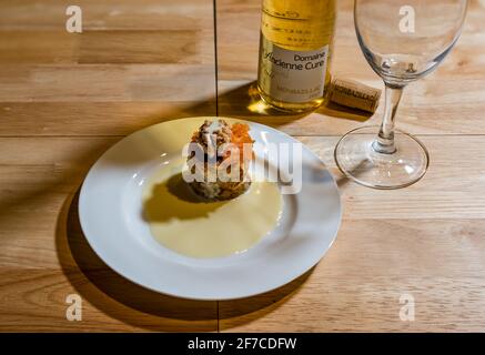 Degustationsmenü feines Dining Pudding oder Süßspeise auf weißem Teller serviert: Karotten- & Walnuss-Frangipane-Kuchen mit Pudding & weißem Monbazillac-Pudding-Wein Stockfoto