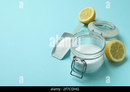 Mit saurem Pulver und einer halben Zitrone auflöffeln und einfüllen Auf blauem Hintergrund Stockfoto