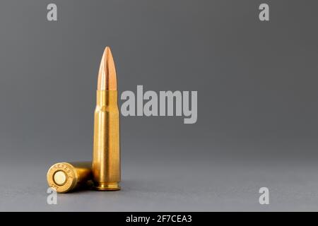 Zwei Kugeln auf grauem Hintergrund. Patronen Kaliber 7.62 für Kalaschnikow Sturmgewehr Nahaufnahme mit Kopierraum. Stockfoto