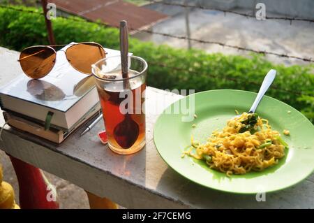 Sonnenbrille mit neuartigen Büchern und Tagebuch-Buch-Erinnerung an Details Zwischen Reise Reisen von Reisenden thai Menschen und Indonesien lokalen Essen Frühstück und Tee Stockfoto