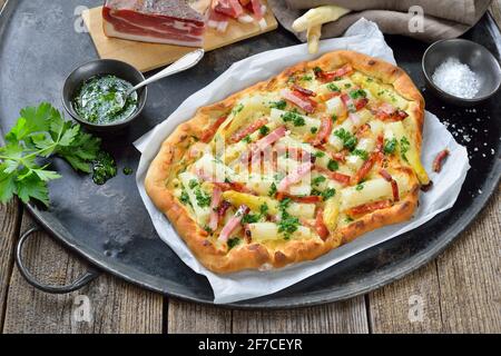 Flambee-Tarte aus dem Elsass mit frischem weißem Spargel, Südtiroler Speck, Petersilie mit Olivenöl und Parmesankäse Stockfoto