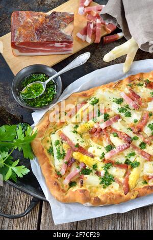 Flambee-Tarte aus dem Elsass mit frischem weißem Spargel, Südtiroler Speck, Petersilie mit Olivenöl und Parmesankäse Stockfoto