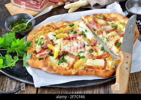 Flambee-Tarte aus dem Elsass mit frischem weißem Spargel, Südtiroler Speck, Petersilie mit Olivenöl und Parmesankäse Stockfoto