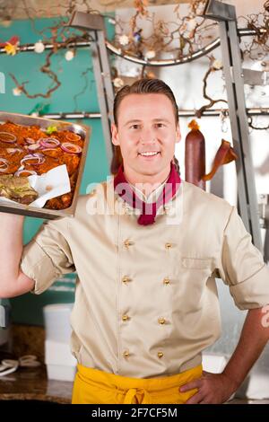 Arbeiten in einem Metzgerladen - ein Metzger mit Grill Steaks Stockfoto